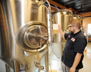 Brick Works head brewer Justin Colatrella checks a new batch of beer in Smyrna.